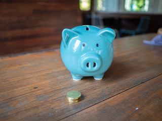 Fototapeta premium Blue piggy bank with coins. The idea of saving money for life