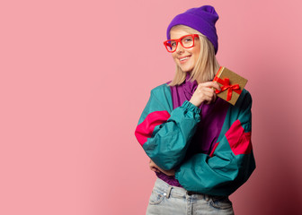 Beautiful blonde woman in 90s clothes with gift box