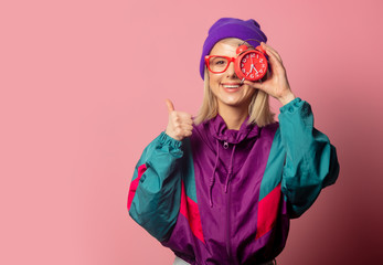 Beautiful blonde woman in 90s clothes with alarm clock