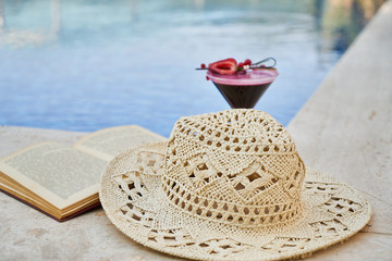 book, hat and alcoholic fruit cocktail