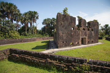 Old brick fortress walls of Fort Zeelandia in the subtropics against a background of green trees...