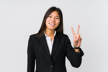 Young asian business woman showing victory sign and smiling broadly.