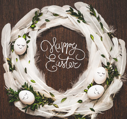 Happy Easter. Congratulatory easter background. Easter eggs in white feathers on a wooden...