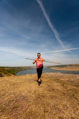 Fototapeta na wymiar A man is engaged in curative gymnastics with a pole on the nature. Healthy lifestyle.
