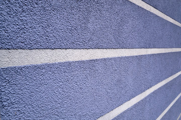 Fototapeta na wymiar Close up of a blue wall of a house with some white stripes. Seen in Germany, April 2019
