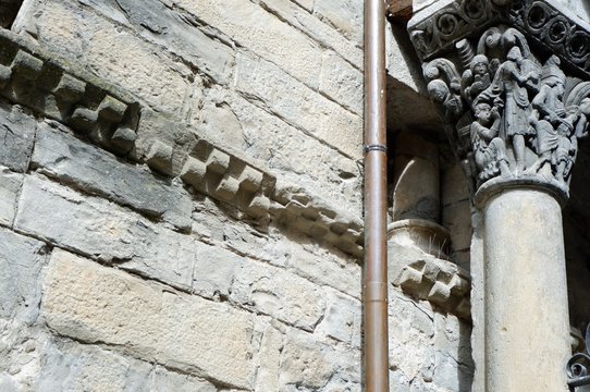 Grey stone column and wall with unique architectural ornamentation "jaque" or "checkered taqueado / ajedrezado on the wall of Jaca's Cathedral. Huesca, Aragon, Spain