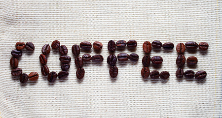 Coffee inscription lined with coffee beans on a burlap sack