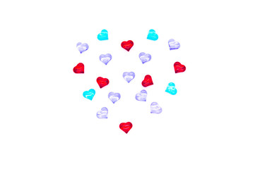Valentine's Day holiday celebration concept. Red, blue and lilac glass hearts laid out in the shape of a heart on a white background. A big heart is made up of little hearts.