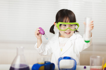 toddler girl pretend play  scientist  role  at home against white background