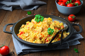 Chicken and Vegetables Bulgur in a Pan over Wooden Background