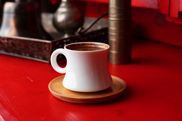 Turkish coffee in a cup on a red background