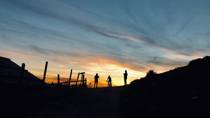 Fototapeta na wymiar Menschen bei Sonnenuntergang am Berg