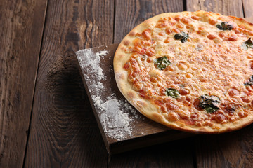 Italian cuisine. Pizza on a wooden background