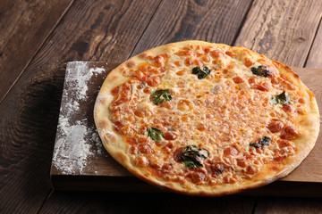 Italian cuisine. Pizza on a wooden background