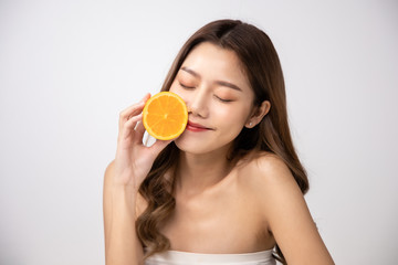 Beautiful Young Asian Woman short hair  with Clean Fresh Skin. Face care, Facial treatment, Cosmetology, beauty and healthy skin and cosmetic ideas concept.pretty woman holding half of orange .