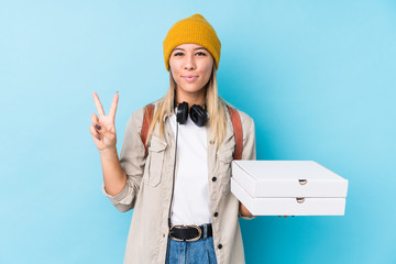 Young caucasian woman holding pizzas isolated showing number two with fingers.