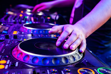 Dj mixes the track in nightclub at party. Body part on the DJ's music control panel