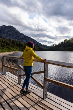 Reflection of a traveler with a yellow jacket on a viewpoint at the Hidden Lake in Bariloche, Argentina