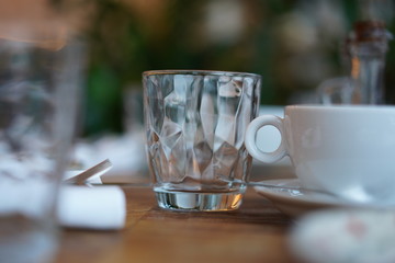 Empty transparent glass cup on a wooden table in a restaurant.