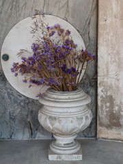 Ferrara, Italy. Certosa Monumental Cemetery. Dried flowers in marble vase.