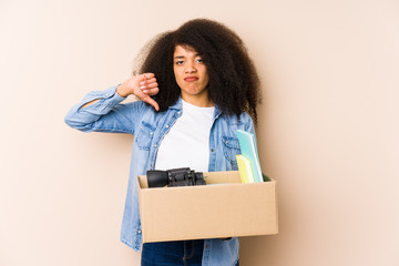 Young afro woman moving home isolated Young afro woman showing a dislike gesture, thumbs down....