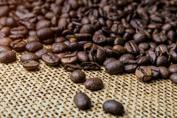 Grains of roasted coffee scattered on the table. Macro image.