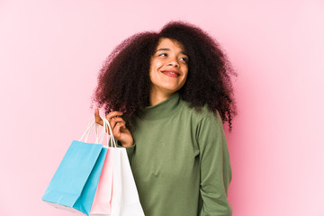 Young afro woman shopping isolated Young afro woman buying isolaYoung afro woman holding a roses isolated dreaming of achieving goals and purposes< mixto >