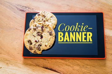 Cookies mit einem Tablet zur Verdeutlichung von Cookie Bannern für Websites mit Aufschrift...