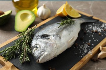 Fresh Dorado fish and cooking ingredients on grey background, close up