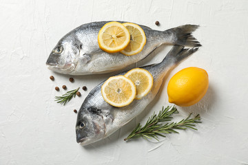 Fresh Dorado fishes, pepper, lemon and rosemary on white background, top view