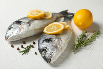Fresh Dorado fishes, pepper, lemon and rosemary on white background, close up