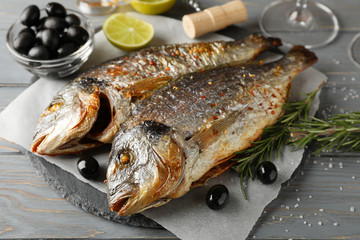 Grilled Dorado on garnished wooden background, close up
