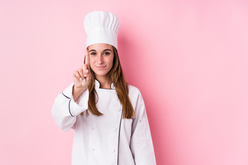 Young caucasian chef woman isolated showing number one with finger.