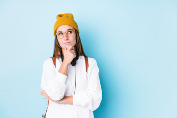 Young student woman isolated looking sideways with doubtful and skeptical expression.