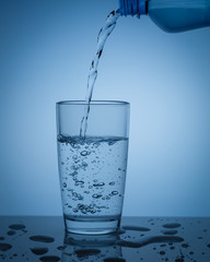 Pouring clean water from a bottle into a glass. Copy space.