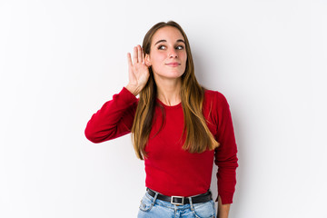 Young caucasian woman posing isolated  trying to listening a gossip.