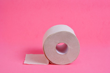 Roll of toilet paper on a pink background.