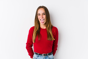 Young caucasian woman posing isolated  funny and friendly sticking out tongue.