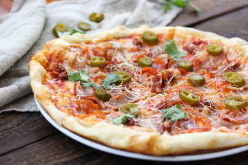 Italian cuisine. Pizza on a wooden background, rustic style