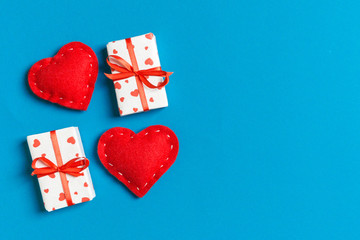 Top view of gift boxes and red textile hearts on colorful background. St Valentine's day concept with copy space