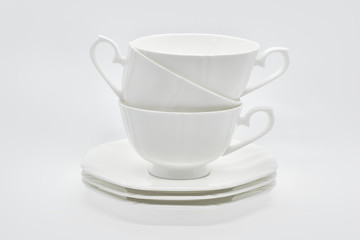 White porcelain cup with a saucer for tea or coffee, demitasse or teacup. Crockery on white background.