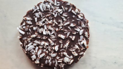 A round and delicious chocolate cake sprinkled with pieces of coconut