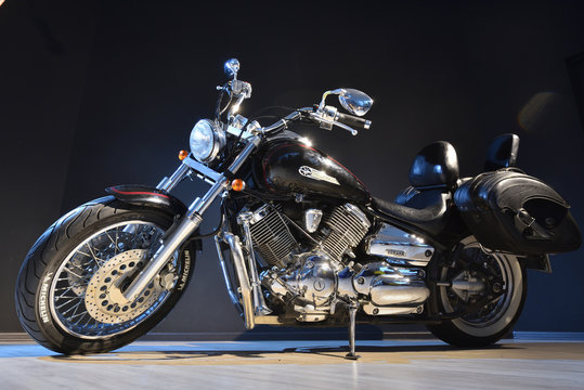 Stariy Oskol, Russia - February 25, 2019: A black Yamaha Dragstar motorcycle with chrome against the black wall in the photo studio.
