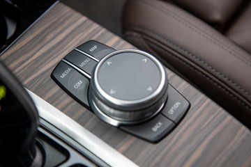 Closeup of multimedia system control buttons on a wood panel in a modern premium luxury car. close-up, soft focus.