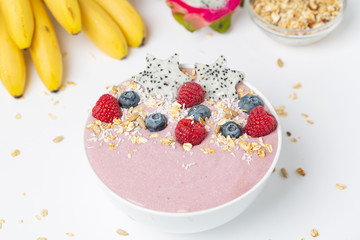 Healthy breakfast bowl: blueberry smoothie with raspberries, bananas, pitaya and granola. 