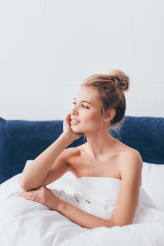 beautiful positive woman sitting in bed in morning