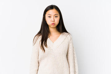 Fototapeta premium Young chinese woman isolated blows cheeks, has tired expression. Facial expression concept.