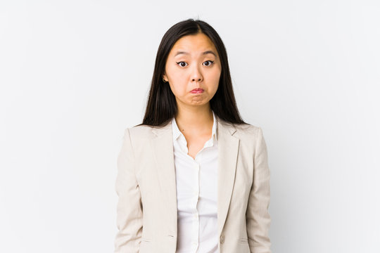 Young chinese business woman isolated shrugs shoulders and open eyes confused.