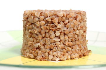 Cooked buckwheat porridge on plate. Isolated on a white background, with clipping path.
