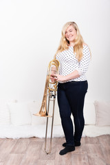 Porträt einer jungen Posaunistin eines Philharmonischen Orchesters mit ihrem Instrument